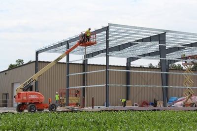 An expansion construction project in progress for a manufacturing facility building using metal building systems